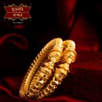 Beautiful Gold Plated Casted Body Bala with intricate traditional designs, displayed on a rich maroon background
